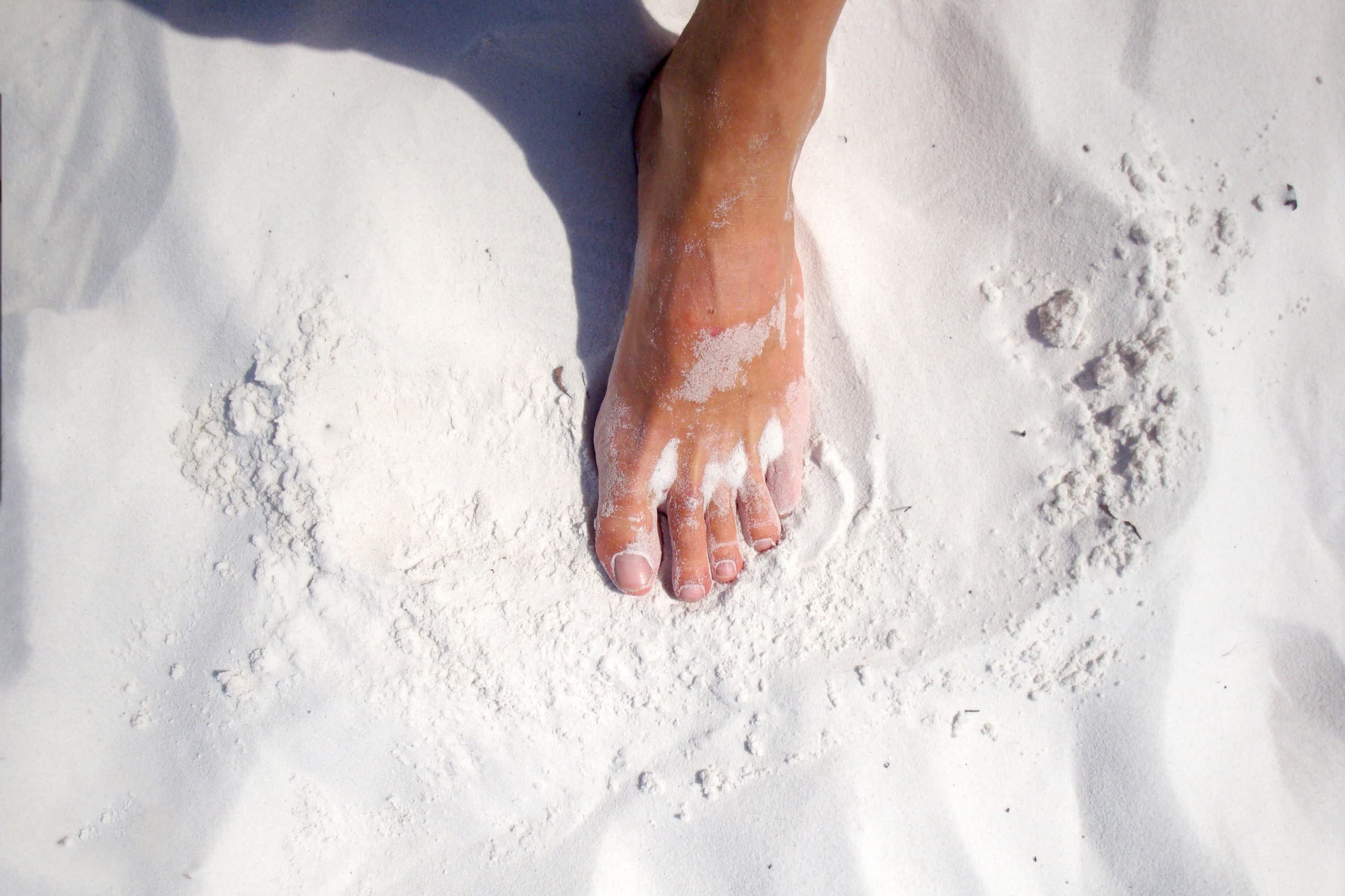 Healthy bare feet in soft white sand